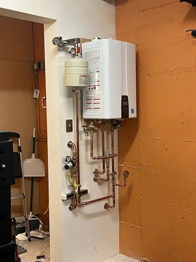 Plumbing technician inspecting water heater connections in Evanston